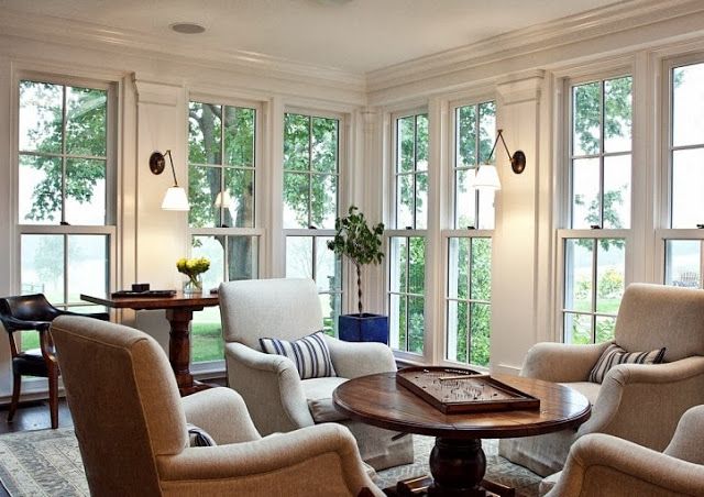 the inside of a house with many different chairs and tables in front of large windows