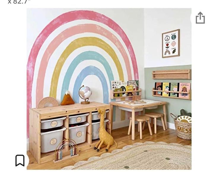 a child's playroom with toys and rainbow painted on the wall behind it