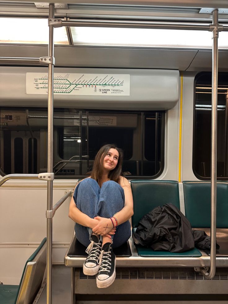 a woman sitting on a train with her legs crossed