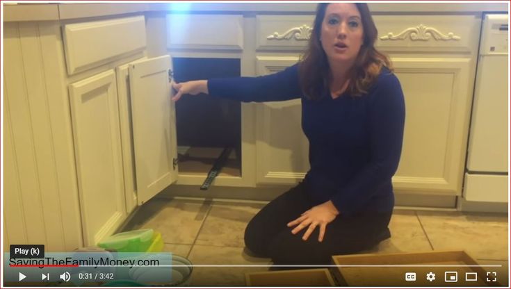 a woman sitting on the floor in front of an open oven door with her hand out