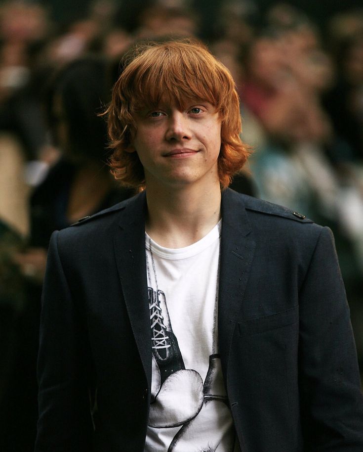 a young man with red hair wearing a black blazer and white t - shirt