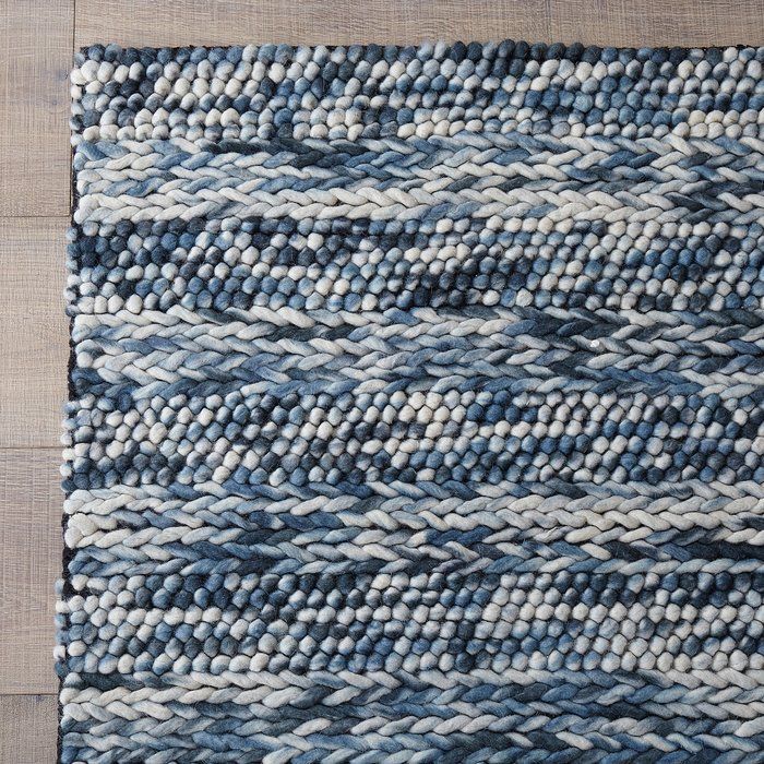 a blue and white rug on top of a wooden floor