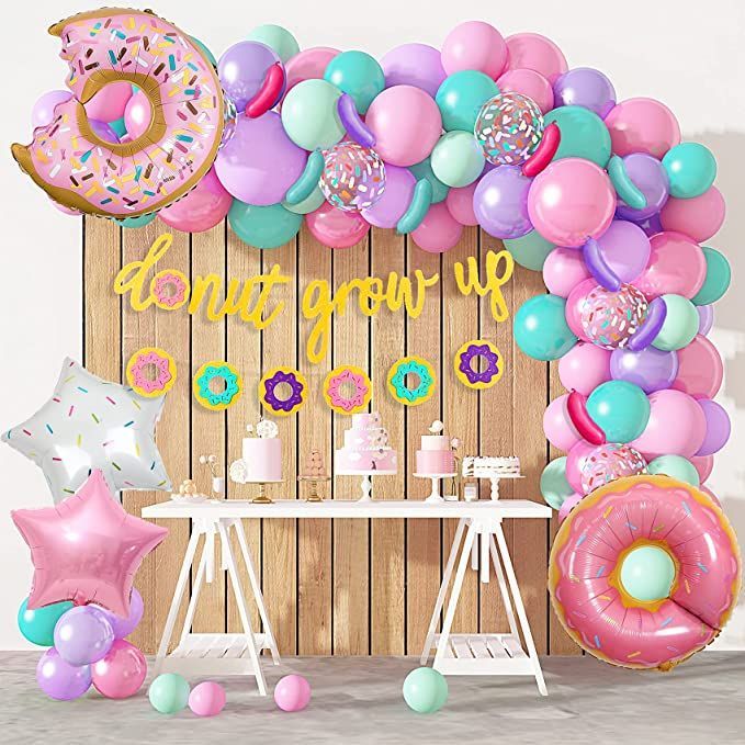 a birthday party with balloons, donuts and stars in front of a wooden backdrop