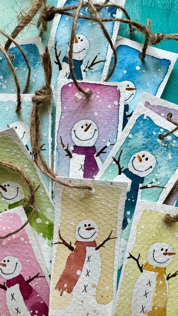 some snowmen are hanging from twine with clothes pins attached to the tags on them