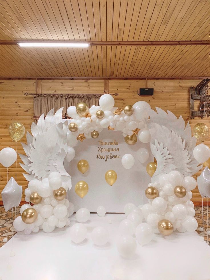 a white and gold balloon arch with balloons