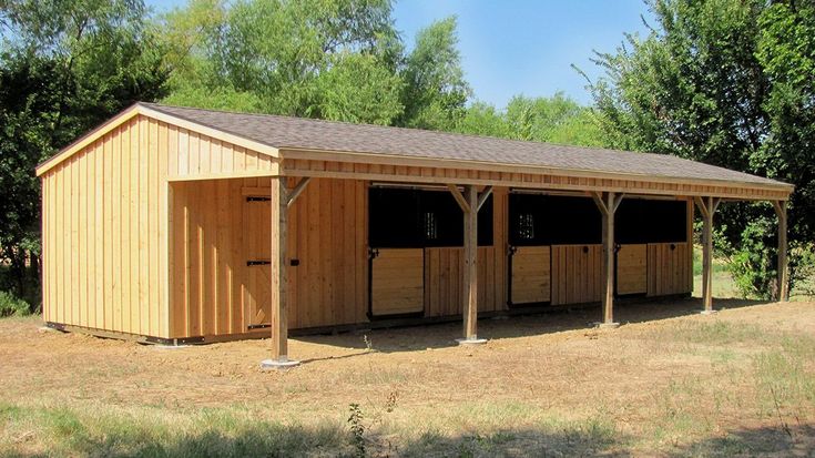 a row of horse stalls in the middle of a field