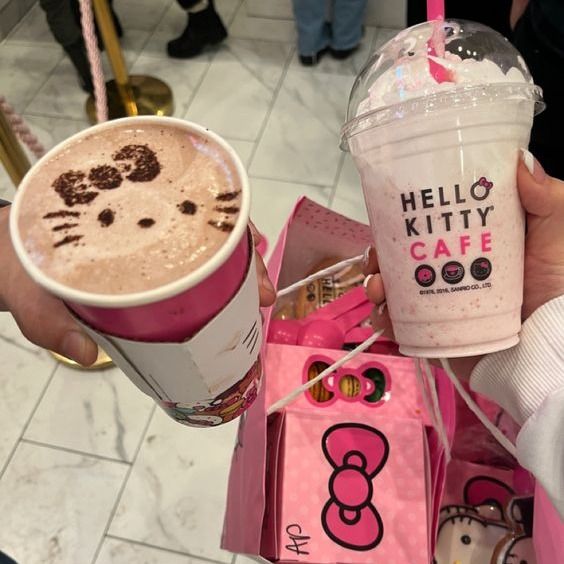 a hello kitty coffee is being held by someone