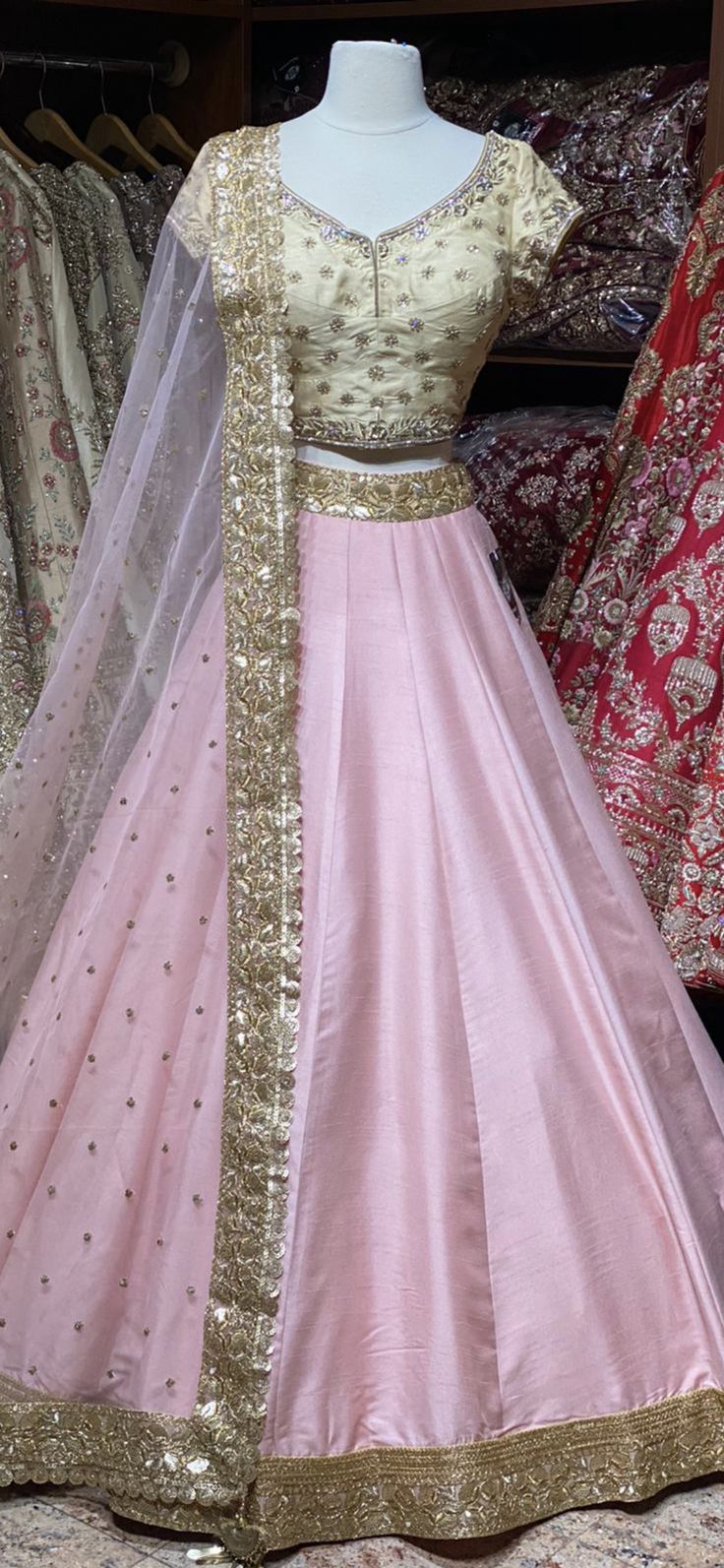 Ballerina pink skirt with gold sequins lace border teamed with contrasting gold floral zardozi, cut dana and stone work blouse and net dupatta. Fabric: Raw Silk This outfit can be customized in multiple colors and specific to client measurements. 90 days of production time is required and are for bulk orders only! Orders are processed in store only! Final fittings/alterations not included. Minimum Order Quantity- 4 pieces Pink Lehenga With Gota Work, Pink Gota Work Salwar Kameez For Reception, Pink Salwar Kameez With Gota Work For Reception, Pink Tissue Silk Dress For Navratri, Pink Lehenga With Sheer Dupatta For Navratri, Pink Anarkali Set With Gota Work For Reception, Pink Sharara With Dori Work For Reception, Reception Choli With Gota Work And Traditional Drape, Traditional Drape Choli With Gota Work For Reception