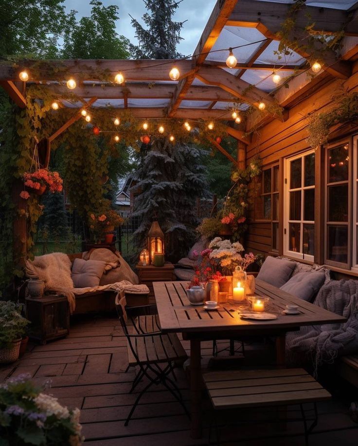 an outdoor dining area with lights strung over the table and couches on the deck