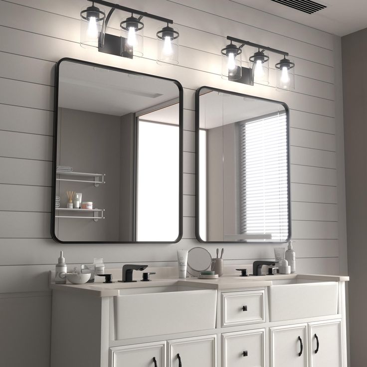 a bathroom with two sinks, mirrors and lights on the wall above them is shown