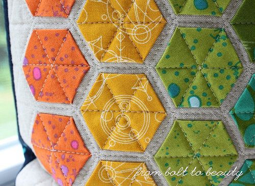 a close up of a patchwork pillow on a window sill