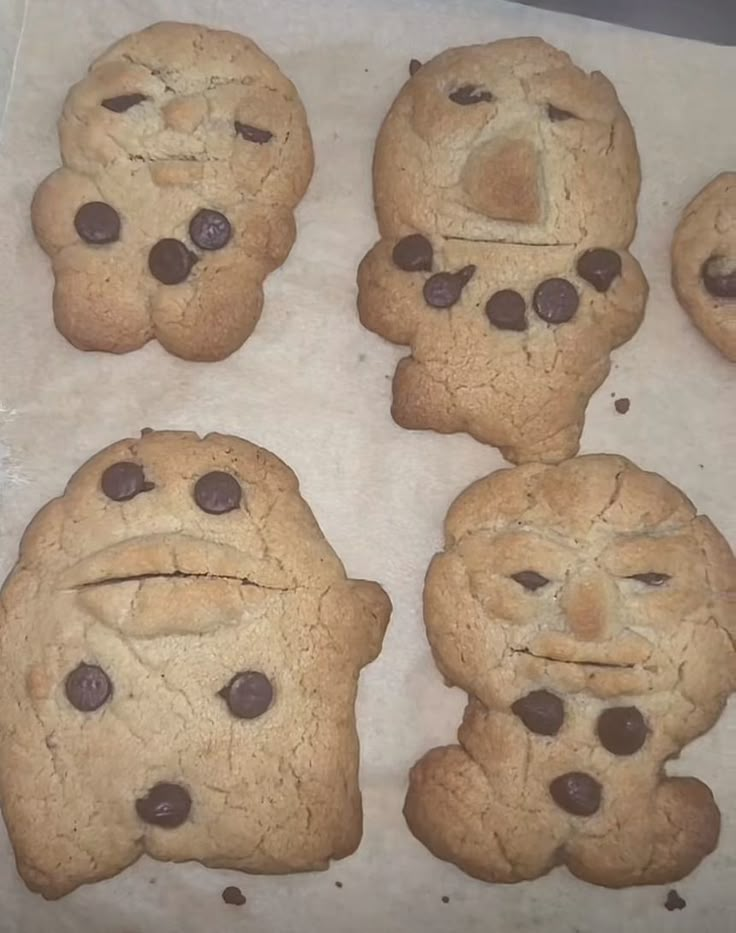 six chocolate chip cookies with faces drawn on them