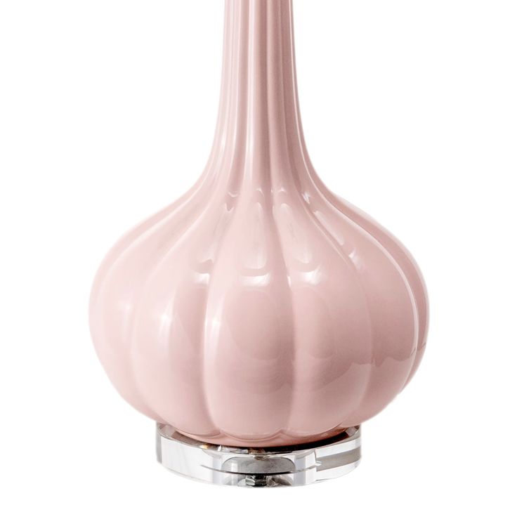 a pink glass vase sitting on top of a metal stand in front of a white background