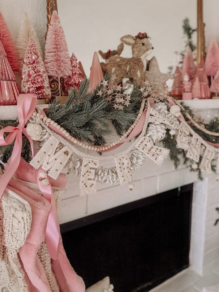 a fireplace decorated with pink and white christmas decorations