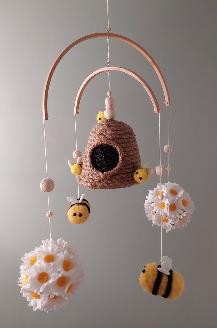 a crocheted mobile with bees and flowers hanging from it