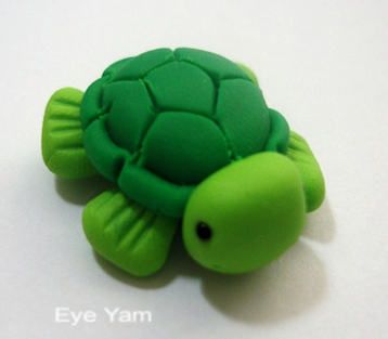 a green turtle toy sitting on top of a white table