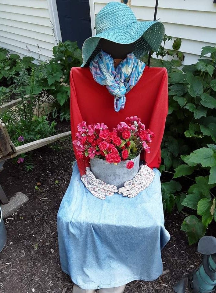 a woman's hat is sitting on top of a potted plant