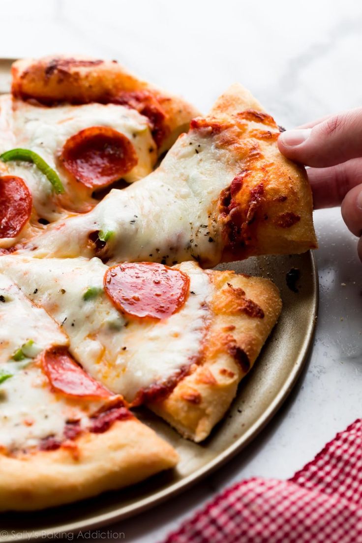 a person taking a slice of pepperoni pizza