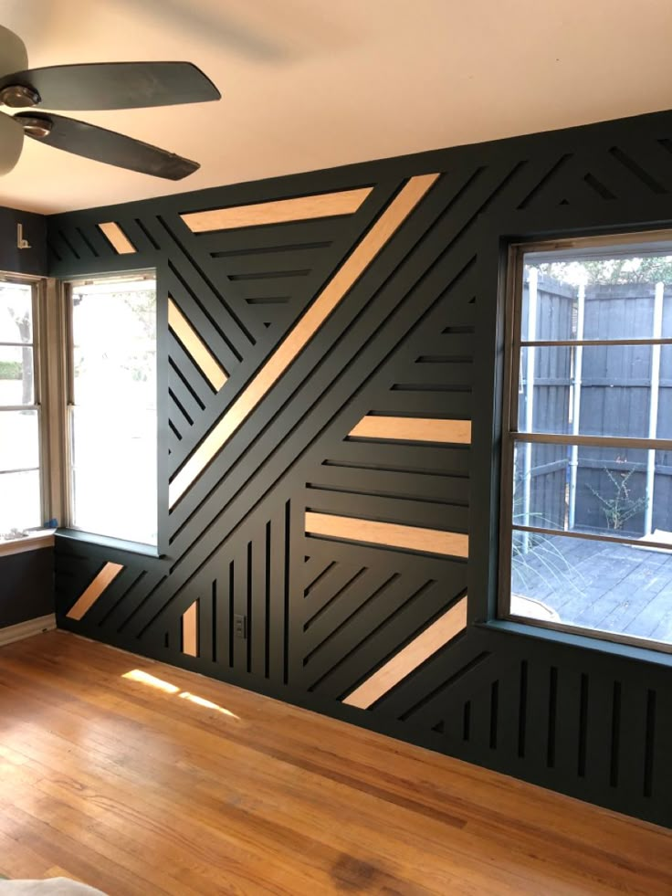 an empty room with wood floors and black walls