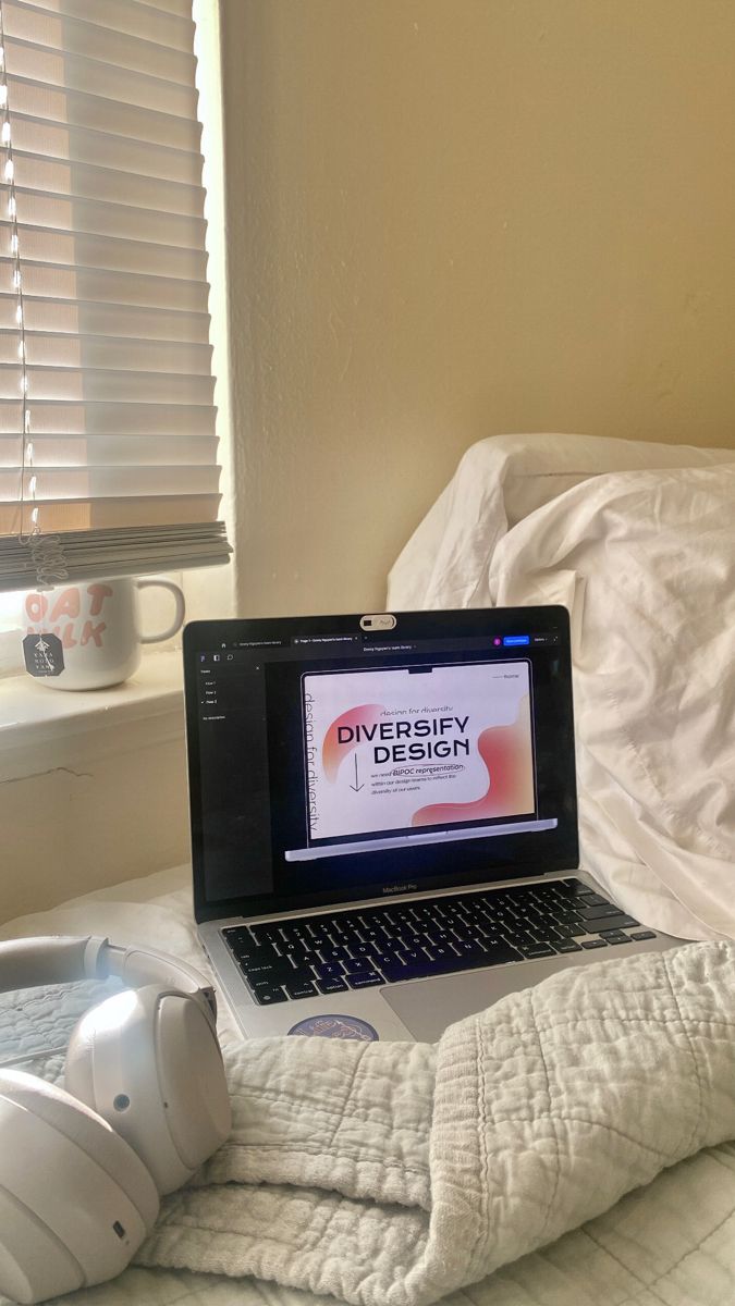 an open laptop computer sitting on top of a bed