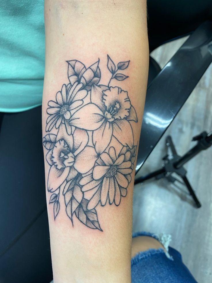 a black and white flower tattoo on the arm