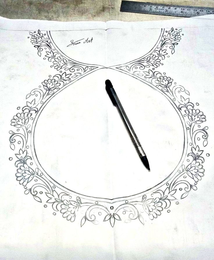 a pen sitting on top of a piece of paper with an ornate design around it