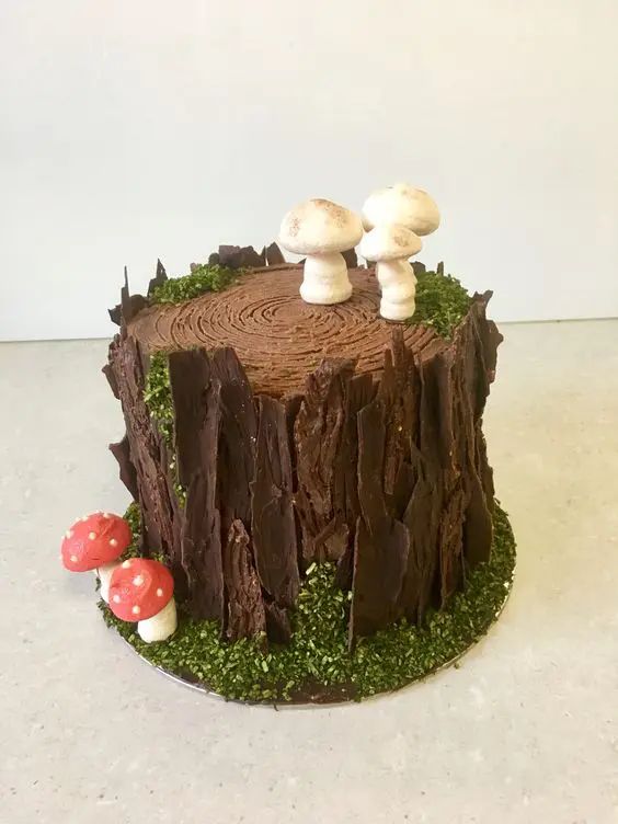 a cake with mushrooms on top of it sitting on a table next to some moss