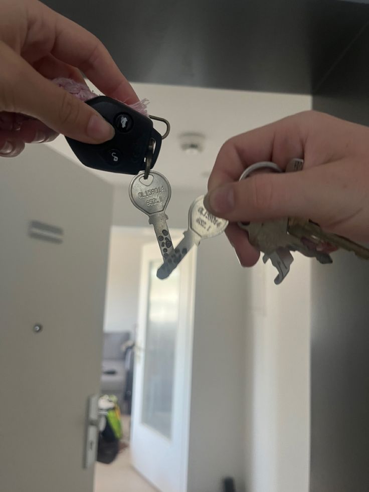 two people exchanging keys to each other in a house