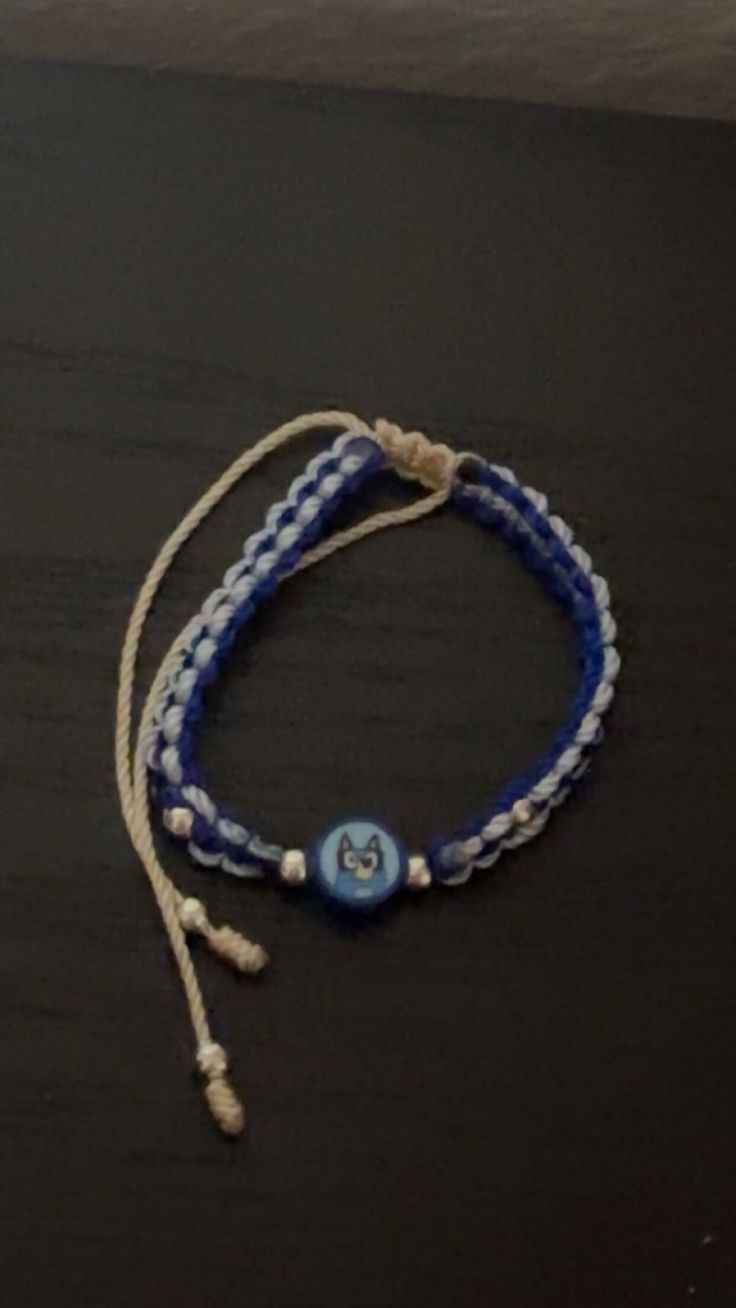 a blue and white bracelet with a button on it