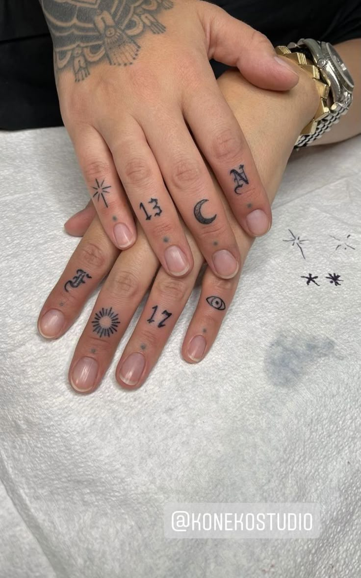 two people with tattoos on their hands and one holding the other's hand in front of them