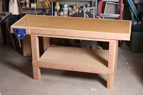 a workbench in a garage with lots of tools on the table and shelves