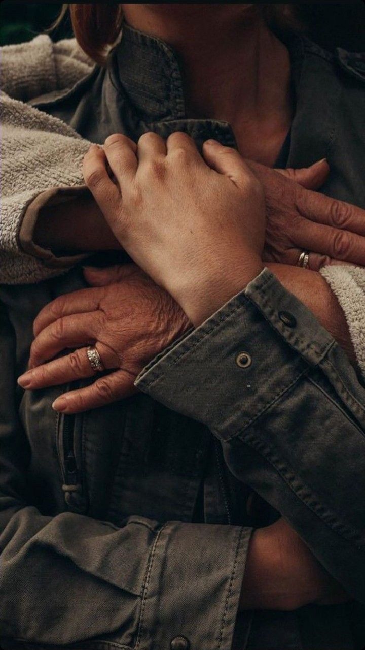 an older woman holding the hands of a younger man