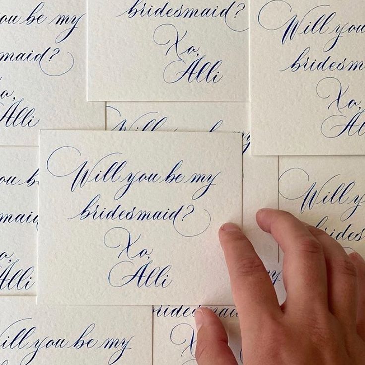 a person's hand on top of some blue calligraphy