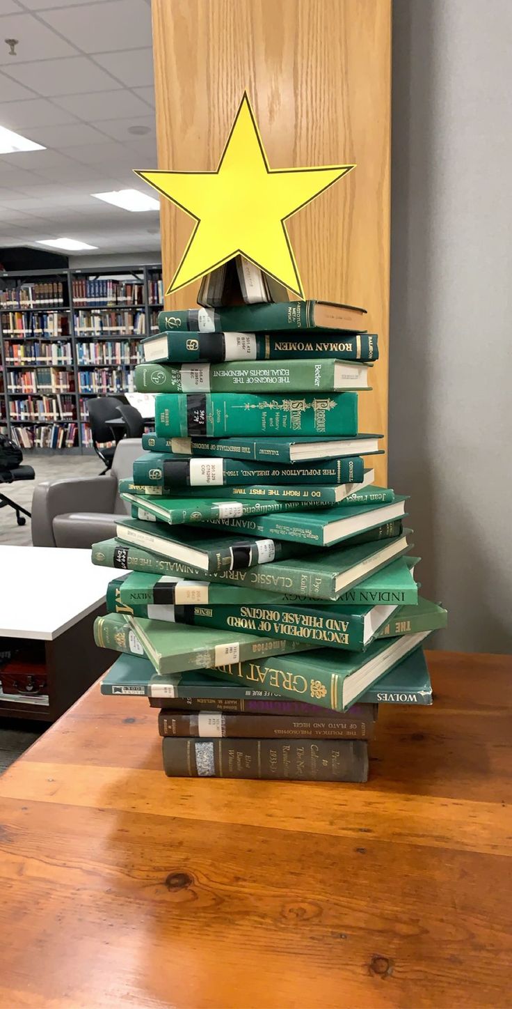 a stack of books sitting on top of a wooden table next to a book shelf