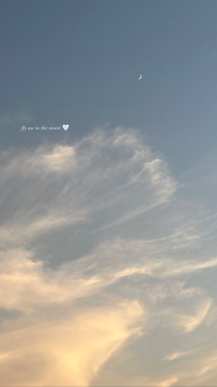 an airplane flying in the sky with a heart on it's tail and some clouds