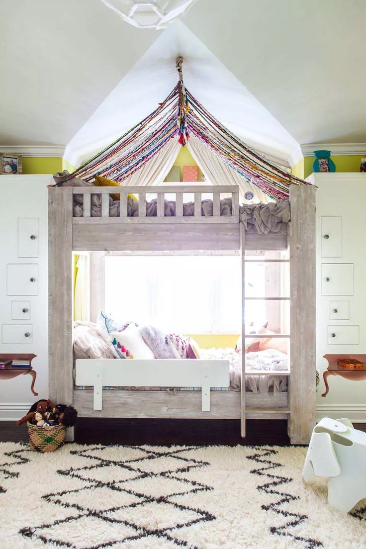 a bedroom with a canopy bed in the middle and rug on the floor next to it