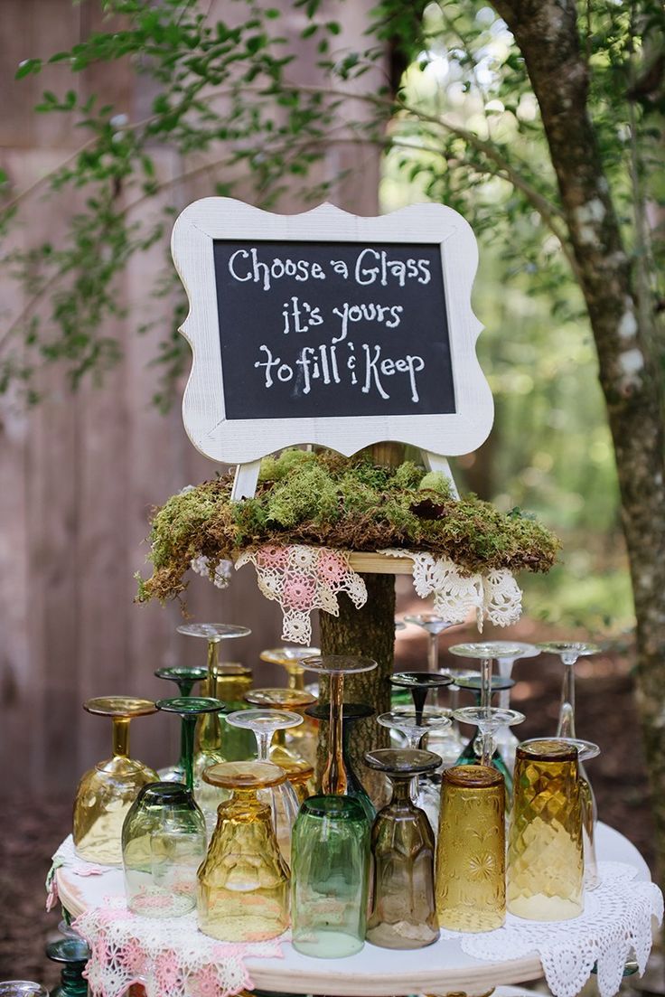 a table topped with lots of jars and bottles filled with moss on top of it