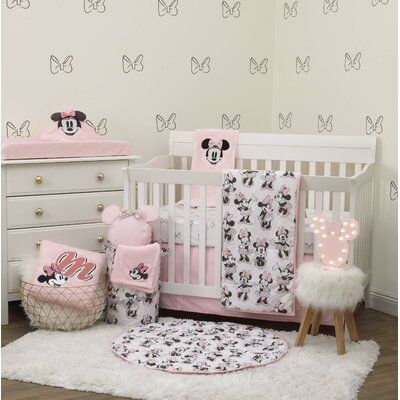 a baby crib with minnie mouse bedding and accessories