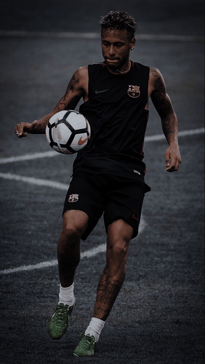 a man in black shirt kicking a soccer ball