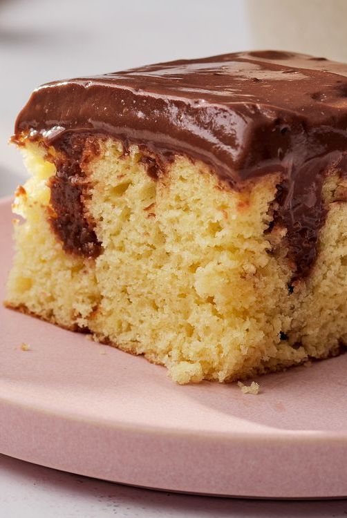 a piece of cake with chocolate frosting on a pink plate