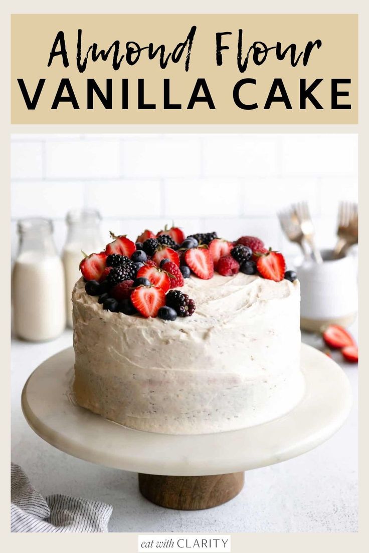 a white cake with berries on top and the words almond flour vanilla cake above it