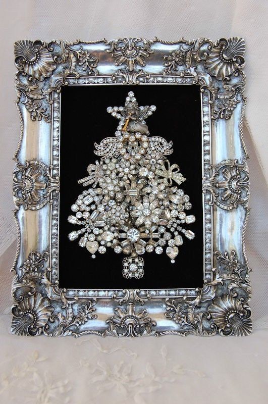 an ornate silver frame with a christmas tree in the center and pearls on the bottom