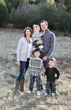 a family poses for a photo in an open field