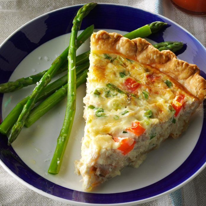 a slice of quiche on a plate with asparagus