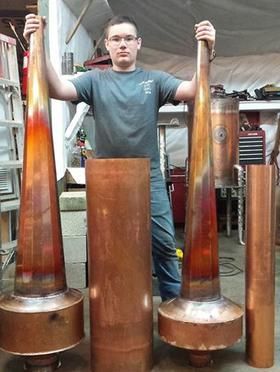 a man standing next to three large vases