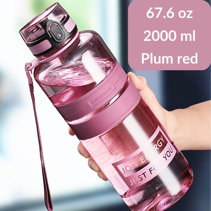 a person holding a pink water bottle in their hand