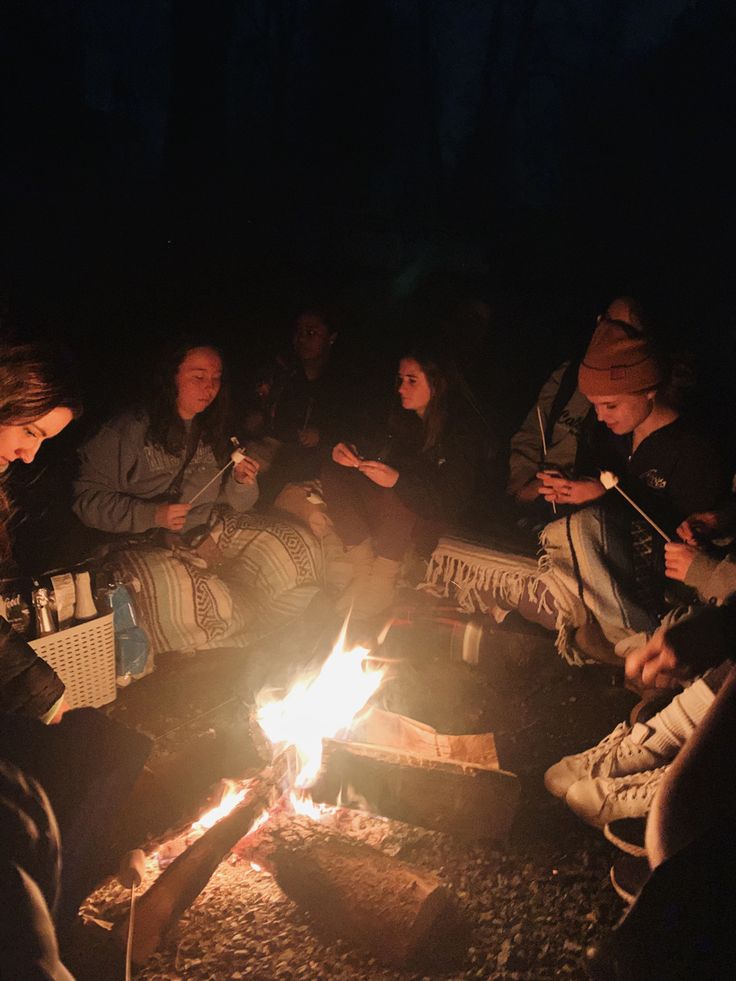 people sitting around a campfire in the dark