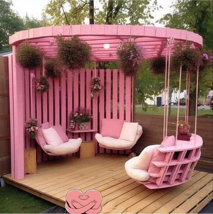 a wooden deck with pink furniture and potted plants on the top, next to a swing set