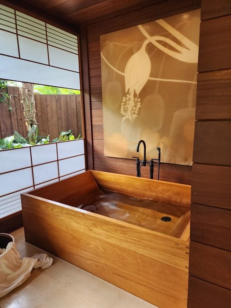 a large wooden bath tub sitting under a window