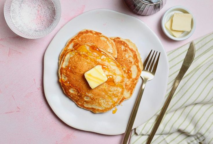 pancakes with butter and syrup on a white plate